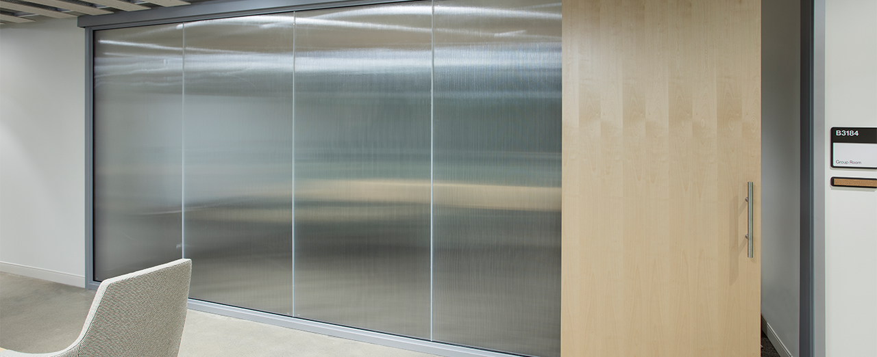 Office hallway with sliding doors closing off meeting rooms.