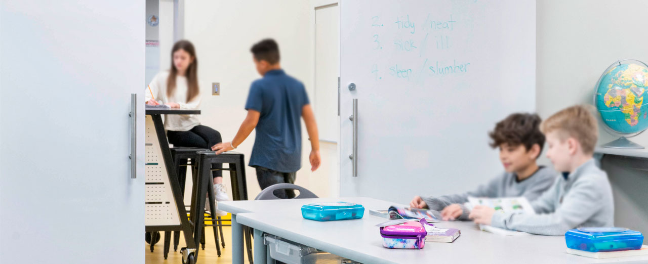 Bright classroom with sliding door opens to collaborative teaching space.