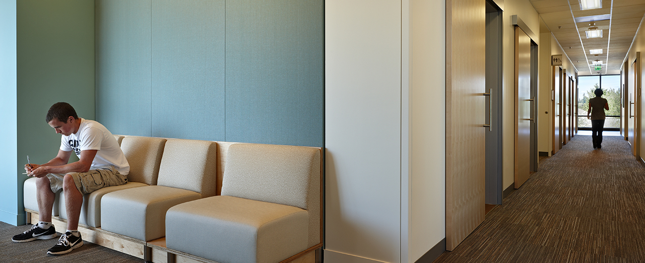 A person waiting on couches next to a hallway featuring AD Systems sliding doors at Everett Clinic.