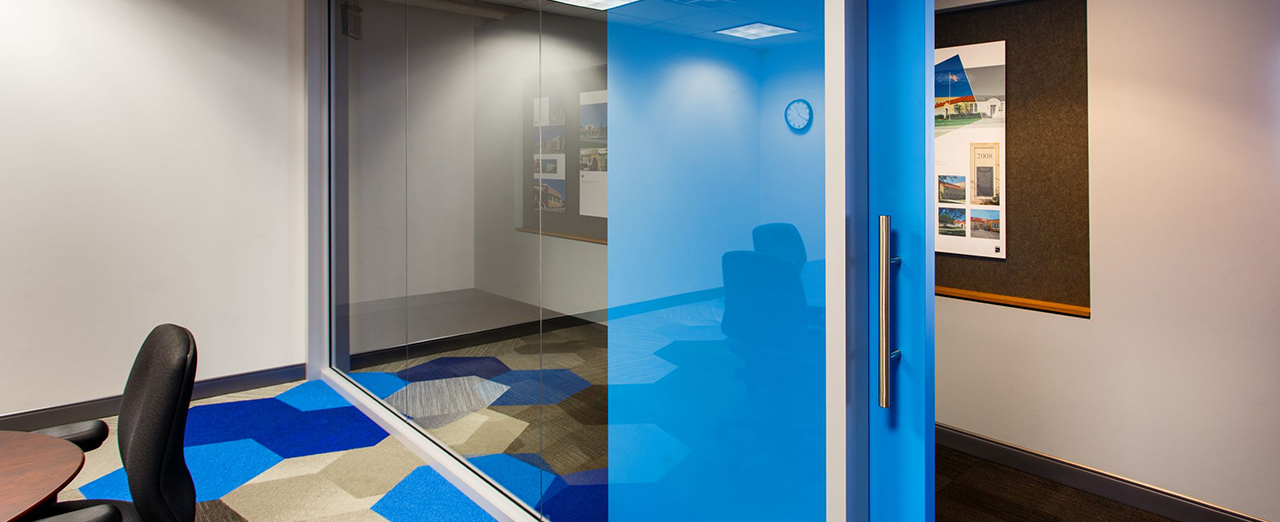 A modern office room equipped with a sleek blue sliding door, enhancing accessibility and space efficiency. 