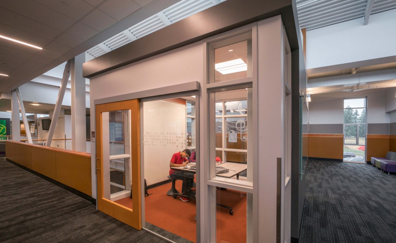 Students using a collaboration room with a closed single leaf sliding door.